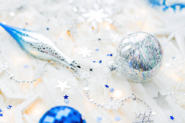 istock Christmas and New Year holiday background with decorations and light bulbs. Silver and blue shining balls, snowflakes and star confetti. 898288002
