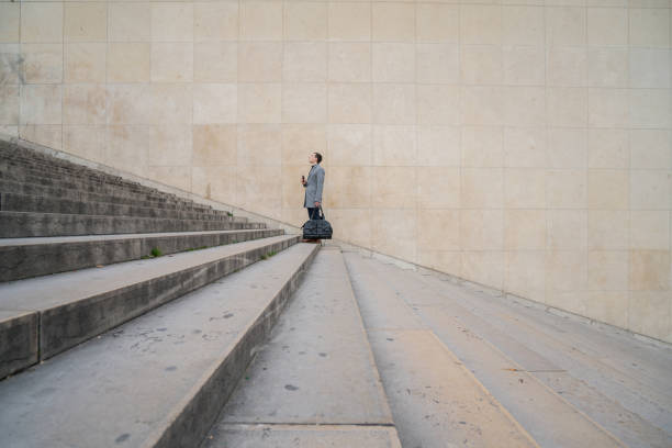 Profile shot of a businessman walking stairs up to work in the city of Paris.Travel success business industry conceptShot in Paris, France