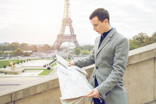 istock Businessman visiting Paris, holding street map - Eiffel Tower 898290772