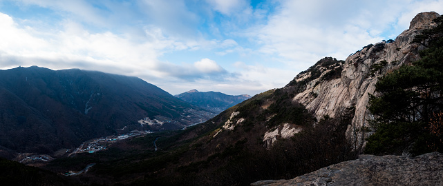 Rocky peak of Mt. Baekunsan overlooking village surrounded by 1,000m high mountains