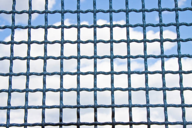 istock Closed metal grate against a blue sky with clouds 898298298