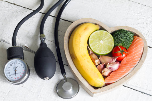 食品と白い板に血 preasure ゲージと健康な心臓ダイエット コンセプト - w2 ストックフォトと画像