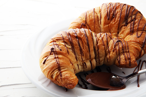 Fresh homemade croissants with chocolate. Sweet bakery concept.