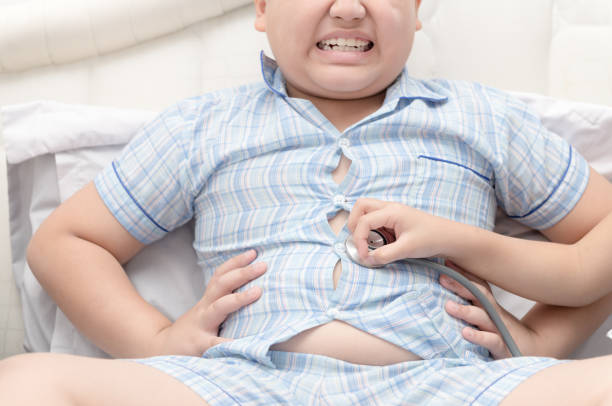 маленькая рука врач проверить желудок - overweight child little boys diabetes стоковые фото и изображения