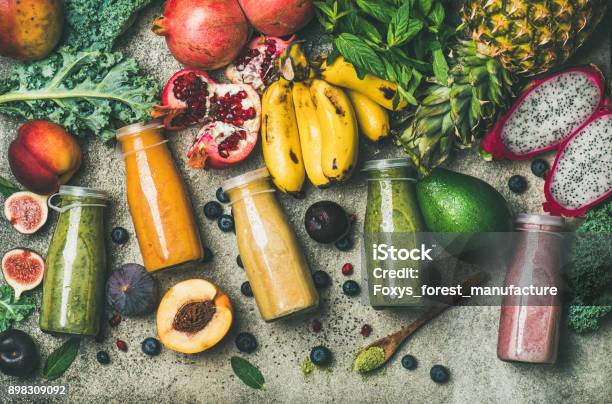 Colorful Smoothies In Bottles With Fresh Tropical Fruit And Superfoods Stock Photo - Download Image Now