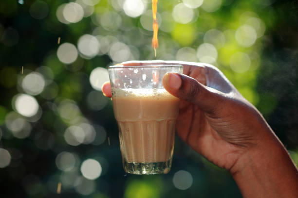 istock Hand holds a glass with hot tea pouring in it 898314806