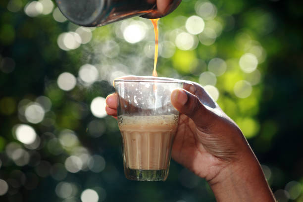 istock Hand holds a glass with hot tea pouring in it 898315028