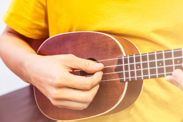 Young playing wooden ukulele