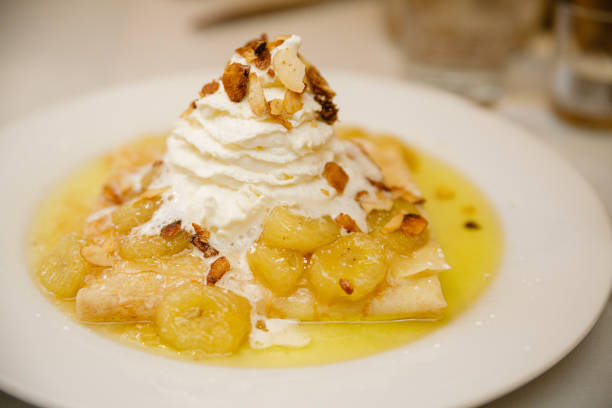 istock Caramelized banana crepe with whipped cream on a white plate 898325310