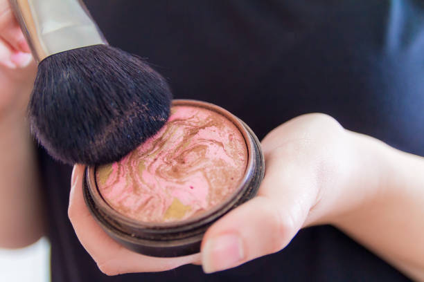Close up of woman hands holding makeup bronzer.