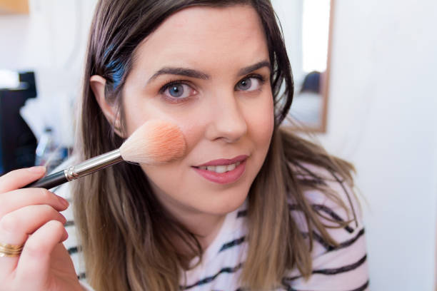 istock Woman applying makeup in her bedroom 898336738