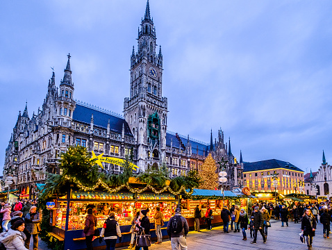 Munich, Germany - December 18th, 2017: people and sales booth at the christmas market in Munich, Germany. the munich christmas market takes place annually on the marienplatz and the surrounding streets and is famous for its stalls selling arts and crafts. directly on the marienplatz the old city hall forms the background.