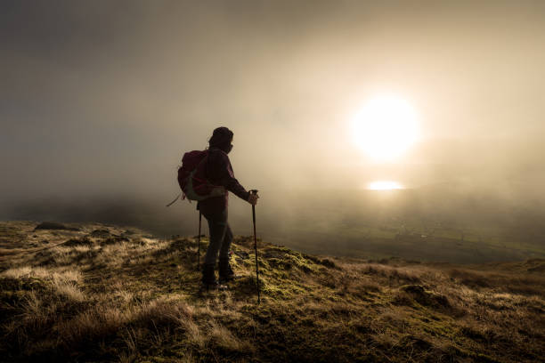 istock Hiker looking at the sunset from hill over a valley 898338354