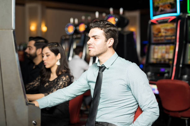 istock Young man playing in slot machines 898339930
