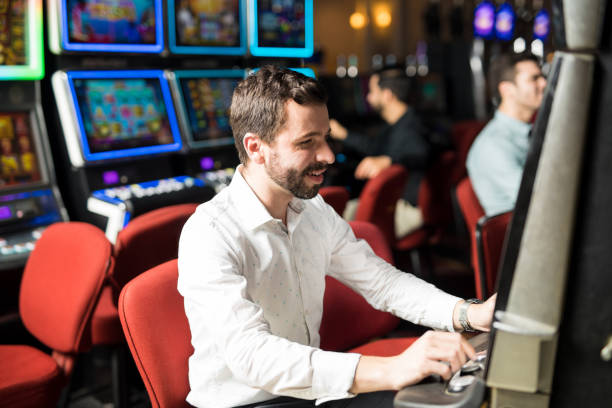 istock Young man playing in a slot machine 898341364