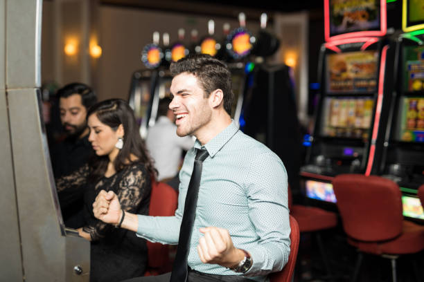 istock Excited man winning in a slot machine 898342272