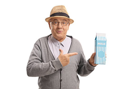 Mature man holding a milk carton and pointing isolated on white background