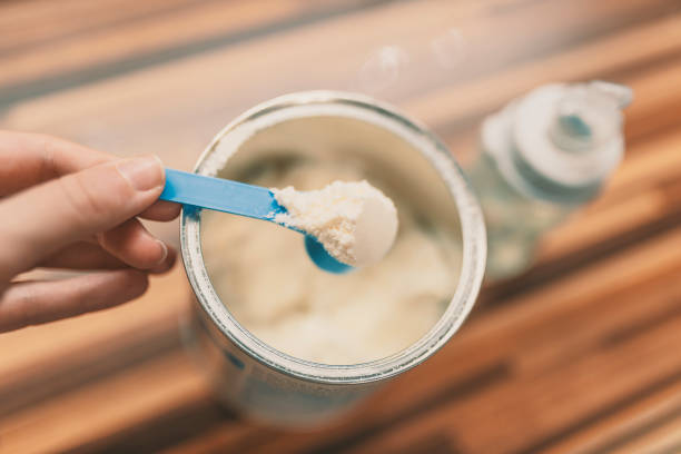 istock Milk powder for baby in measuring spoon on can. 898344406