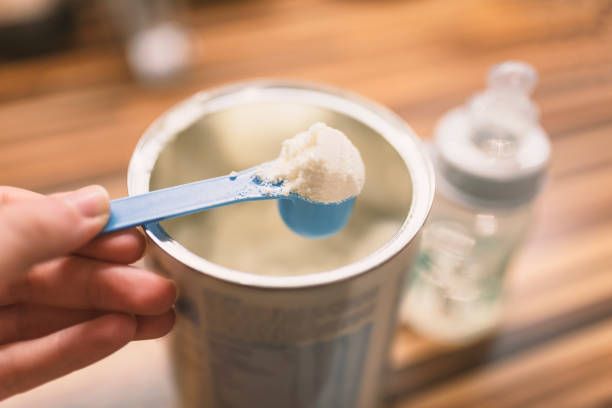 istock Powder milk for baby and blue spoon on light background close-up. 898344414