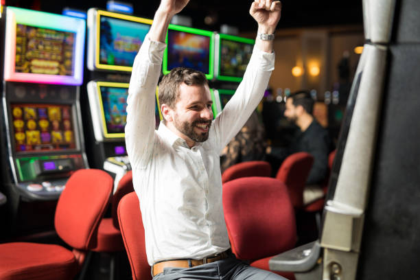 istock Excited man winning in a slot machine 898344954