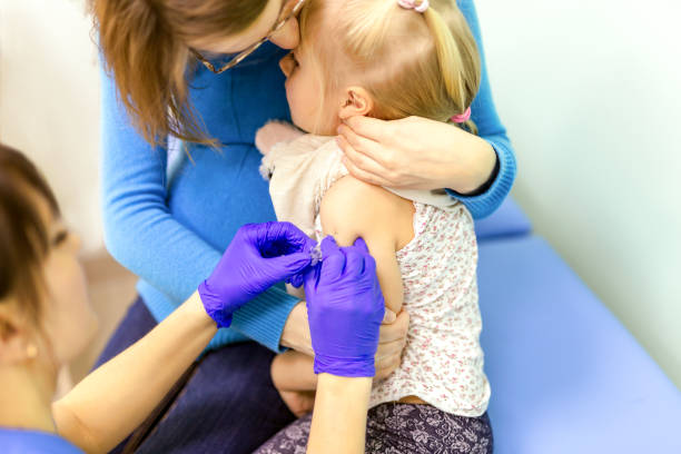 врачи руку со шприцем решений детей вакцинации - injecting flu virus cold and flu doctors office стоковые фото и изображения
