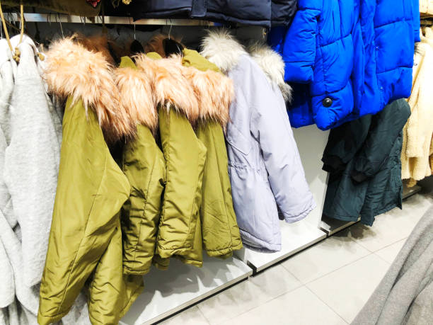 istock Men's and women's down jackets on the counter in the store 898346732