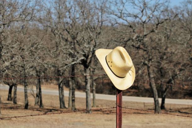 istock Cowboy Hat Hanging on Fence Post 898349022