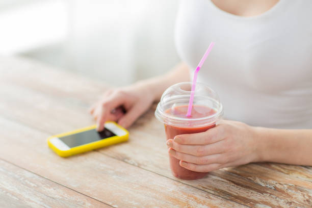 close up of woman with smartphone and smoothie - blueberry smoothie milk shake drink imagens e fotografias de stock