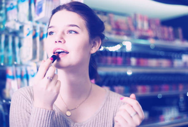istock female customer looking for lipstick in cosmetics shop 898349788