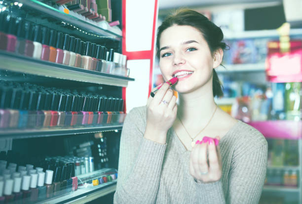 istock female customer looking for lipstick in cosmetics shop 898349834
