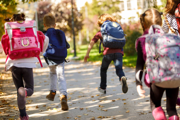istock Group of elementary school pupils running outside 898353208