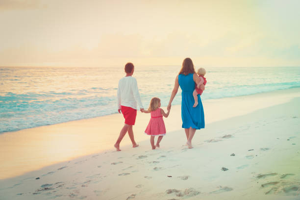istock happy family with kids walk on sunset beach 898355032