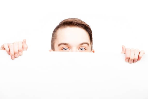 istock Teen boy looking out from blank banner or board 898355370