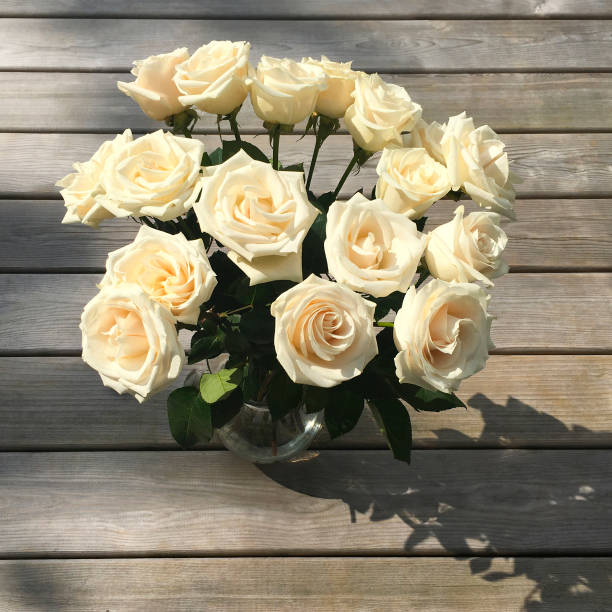 istock Bouquet of White Roses on a Wood Table 898357238