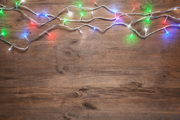 istock Christmas lights on wooden table 898365018