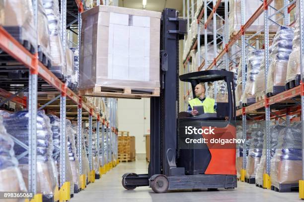 Man With Tablet Pc Operating Forklift At Warehouse Stock Photo - Download Image Now - Forklift, Warehouse, Loading