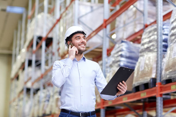 istock man with clipboard and smartphone at warehouse 898365740