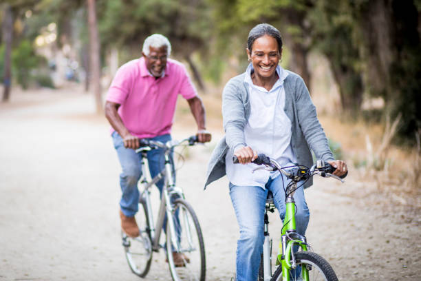 senior pareja afroamericana, montar en bici - action mature adult bicycle senior couple fotografías e imágenes de stock