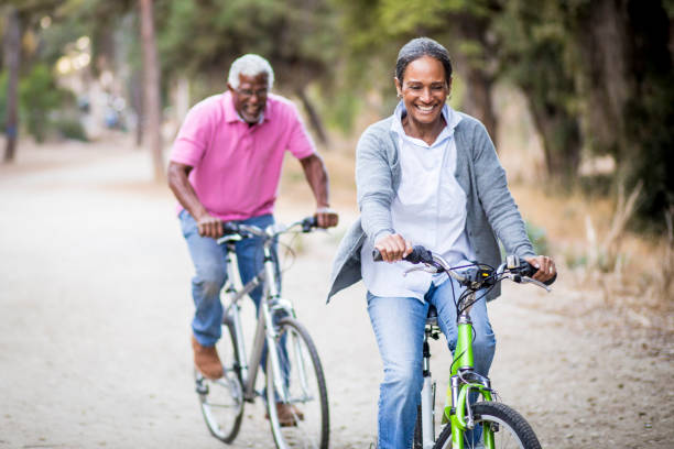 senior african american couple in sella a biciclette - senior adult senior couple exercising african ethnicity foto e immagini stock