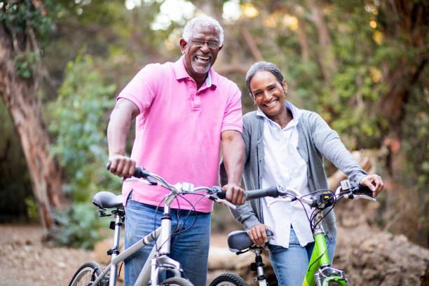 senior pareja afroamericana, montar en bici - action mature adult bicycle senior couple fotografías e imágenes de stock