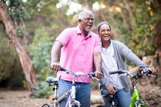 älteres afroamerikanischen paar fahrrad fahren - man walking bike stock-fotos und bilder