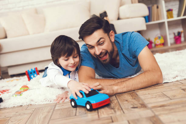 Father has fun with his son. An exemplary father and a boy at leisure. Father has fun with his son. An exemplary father and a boy at leisure. Father plays games with boy. kid toy car stock pictures, royalty-free photos & images