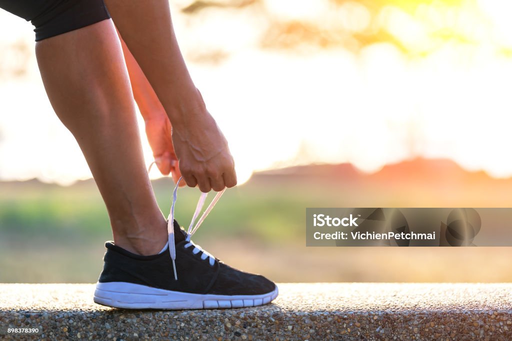 Woman Lacing Up Shoes for a Run Woman lacing up shoes for a run. Active Lifestyle Stock Photo