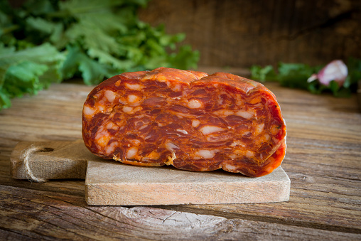 Typical Calabrian italian salami called spianata on wooden table
