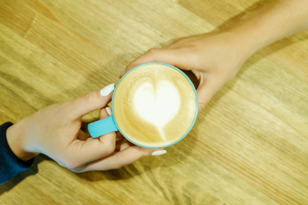 istock Human feelings. Frothy cappuccino between two hands. Friendship pastime 898378586