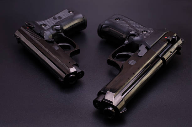 istock two black automatic pistols on a black background 898380380