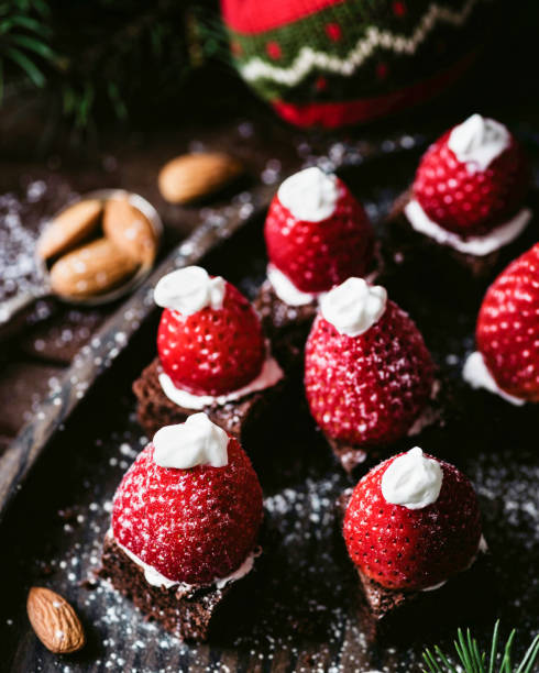 Santa hat brownies on dark background Santa hat brownies on dark wooden background. Closeup view, selective focus ice pie photography stock pictures, royalty-free photos & images