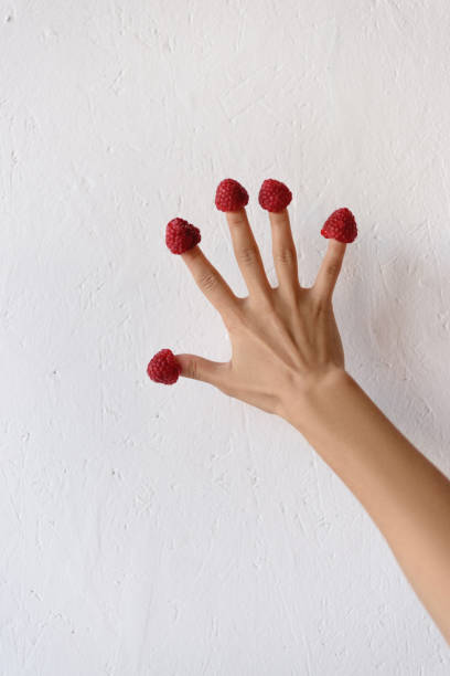 istock raspberries on female hand 898389816
