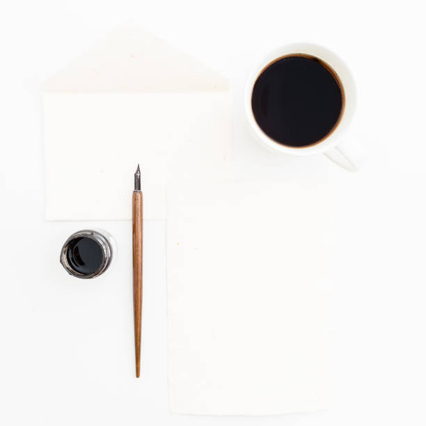 Paper envelope, card, pen and ink with coffee mug on white background. Flat lay, top view. Retro background