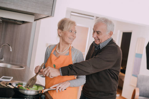 istock Happy senior couple preparing dinner in a kitchen 898395070
